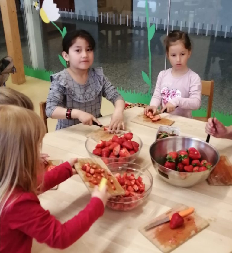 Kinder schneiden Erdbeeren