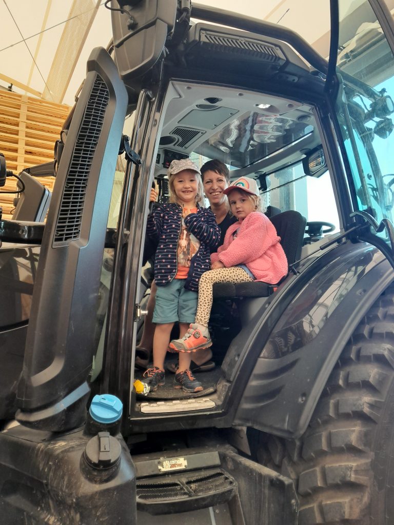 Kinder mit Mutter im Traktor