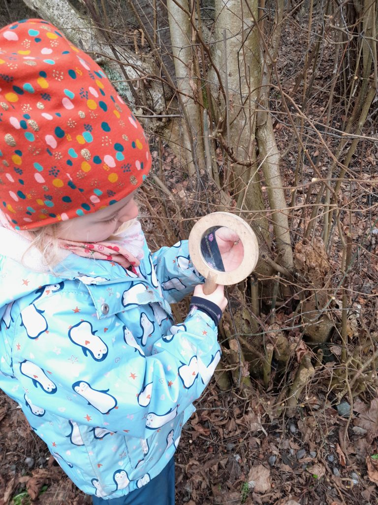 Kind mit Lupe untersucht Knospen